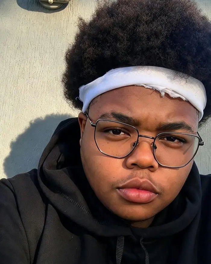 Francy Beatmaker de óculos, faixa branca no cabelo e moletom preto