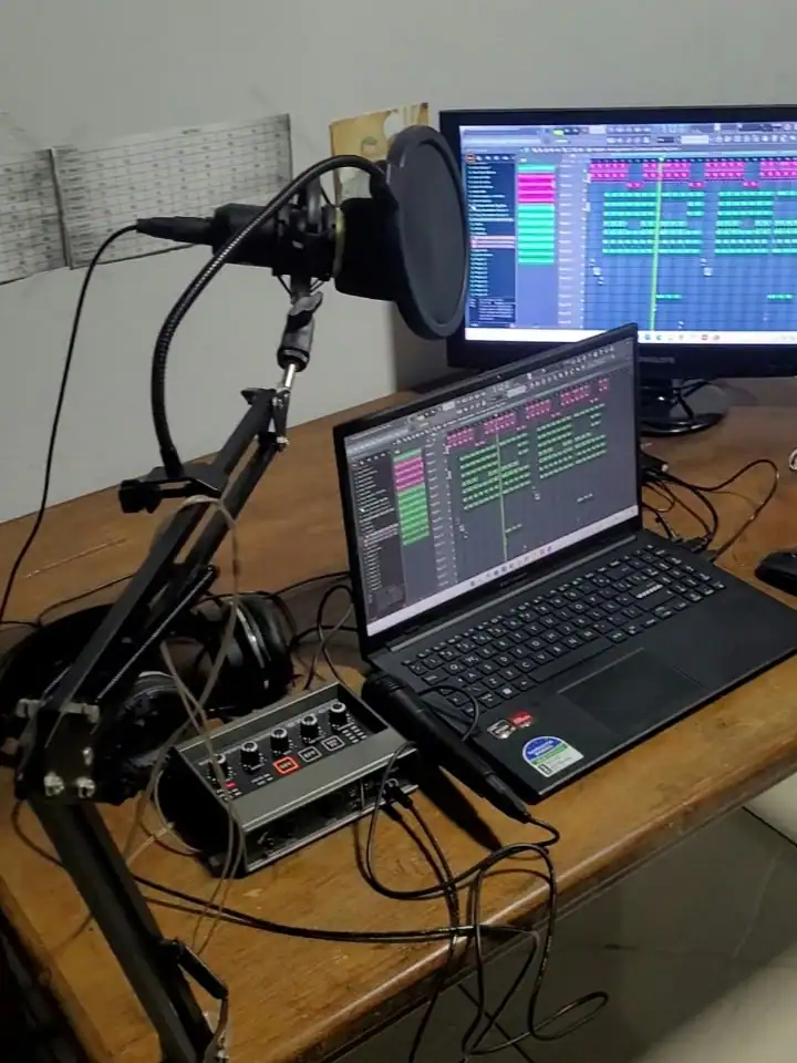 O estúdio da Francy: microfone com pop filter, interface de áudio, notebook e o monitor com o FL Studio aberto